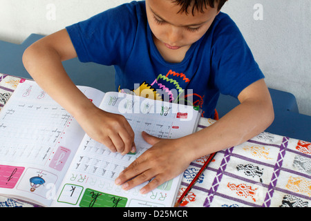 First-grader learning to write, using an eraser Stock Photo