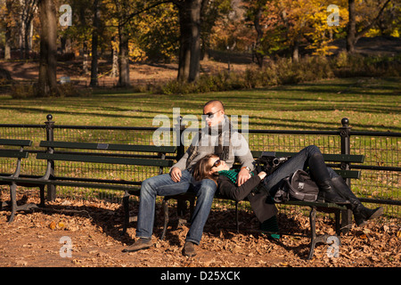 Yong Adult Couple Sleeping on Bench, Central Park, NYC Stock Photo