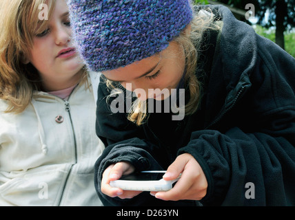 two girls playing on an iphone Stock Photo