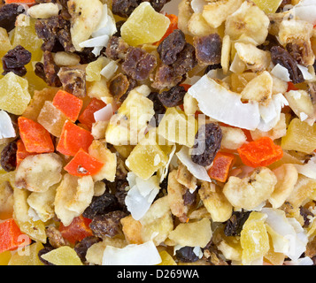 A very close view of a healthy snack mix of coconut, papaya, bananas, pineapple, raisins and dates. Stock Photo