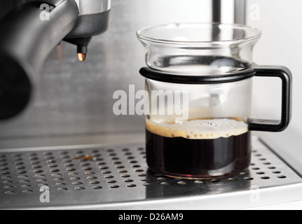 Modern glass cup of black coffee in espresso machine Stock Photo
