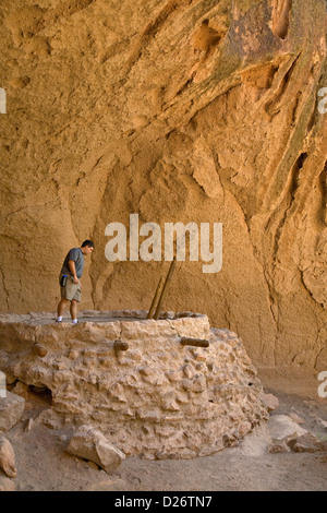 Man looks into reconstructed kiva at Bandelier National Monument, New Mexico Stock Photo