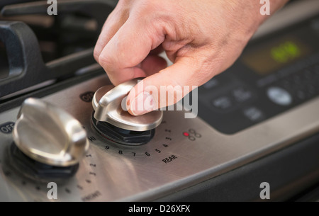 USA, New Jersey, Jersey City, Close-up of hand adjusting stove burner Stock Photo