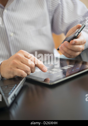 USA, New Jersey, Jersey City, Man using tablet pc, laptop and smartphone Stock Photo