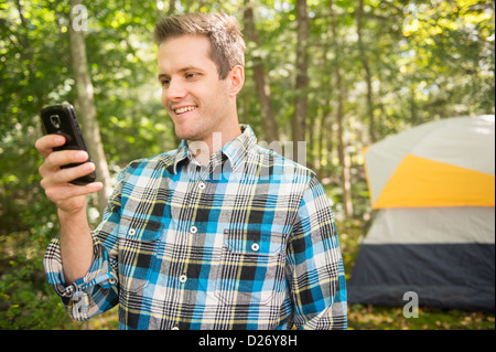 USA, Connecticut, Newtown, Man using cell phone in forest Stock Photo