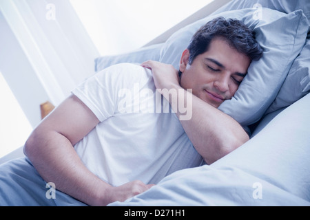 Portrait of young man sleeping in bed Stock Photo