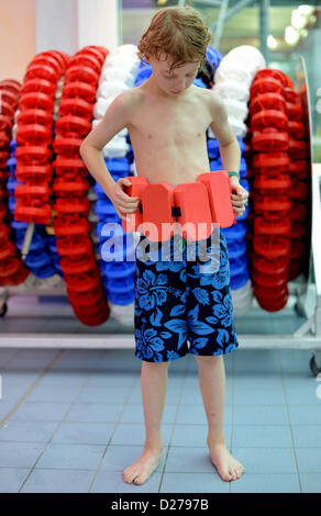 A boy is arranging a swimming belt around his waist. Stock Photo