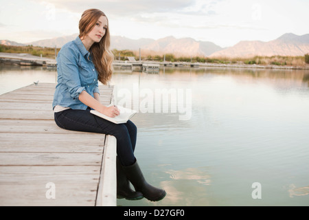 USA, Utah, Salt Lake City, Portrait of young woman sitting on jetty Stock Photo
