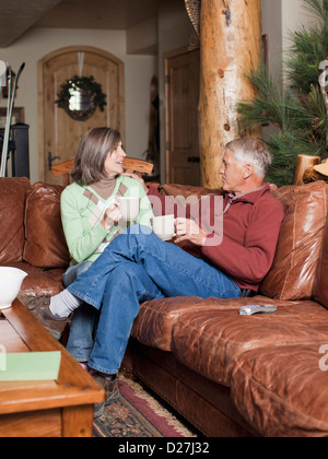 USA, Utah, Salt Lake City, Couple drinking coffee in log cabin Stock Photo