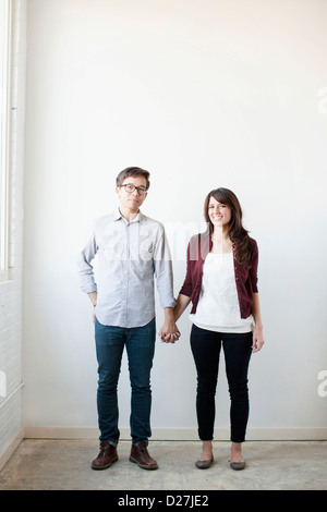Portrait of couple holding hands indoors Stock Photo