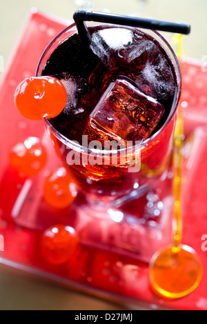 Red drink with ice cubes and black sipper top view Stock Photo