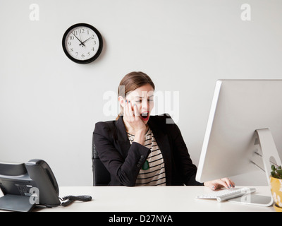 Studio shot of young woman working in office yawning Stock Photo