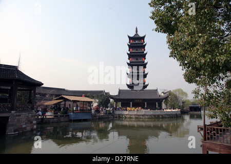 It's a photo of a Old Chinese Tower of a Temple in a city in China. it has many levels and is make of dark wood Stock Photo