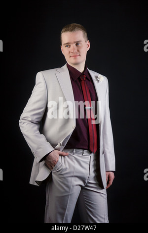 attractive young man in a gray suit and tie on a black background Stock Photo