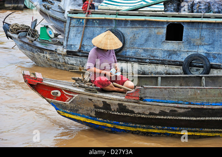 Mekong River, Vietnam, Tien Giang Province  - Woman on a boat counting money Stock Photo