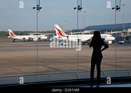 Woman making using a cell phone. Bandaranaike International Airport Colombo. Sri Lanka Stock Photo