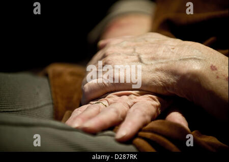 Folded hands rest on the lap of an elderly person in the cultural and community centre Gorbitz in Dresden, Germany, 23 December 2012. The community centre is run by the 'Volkssolidaritaet Dresden' (lit. People's solidarity Dresden), an umbrella organisation concerned with social solidarity, and accommodates a range of social and welfare facilities under one roof catering from nurseries for the elderly to assisted accommodation. Photo: Martin Foerster Stock Photo