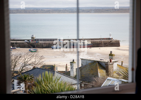View of St Ives harbour and Carbis Bay with the tide out from a holiday let apartment Stock Photo