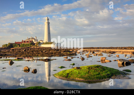 St Mary's Lighthouse near Whitley Bay on the North Tyneside coast,  reflected in a large rock pool adjacent to the causeway. Stock Photo