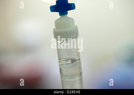 An IV drip chamber connected to saline bag Stock Photo