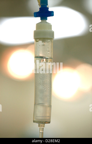 An IV drip chamber connected to saline bag Stock Photo