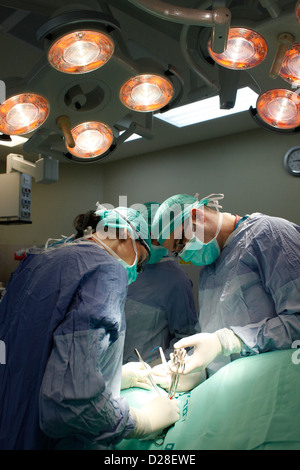 Surgeons wearing surgical mask performing operation in operating room in Rambam hospital Haifa Israel Stock Photo