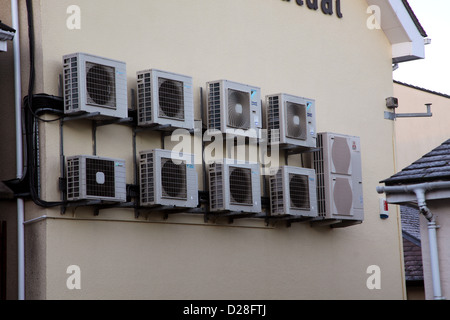 Battery of air  conditioning units on the outside wall of a small office building in Carmarthen, west Wales, January 2012 Stock Photo