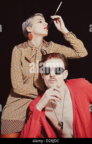 Young stylish couple in sunglasses on black background
