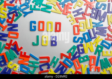 'Good Job' - Refrigerator magnets spell a message out of a jumble of letters Stock Photo