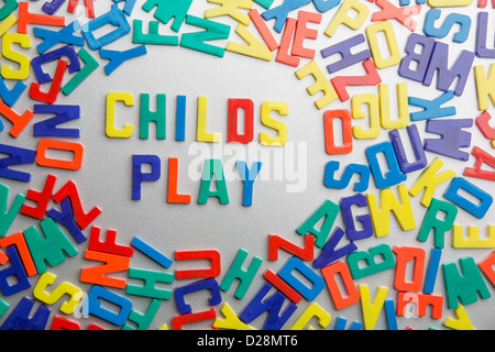 'Childs Play' - Refrigerator magnets spell a message out of a jumble of letters Stock Photo