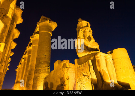 Ancient sitting statue of Ramses II in Luxor Temple lit up at night ...