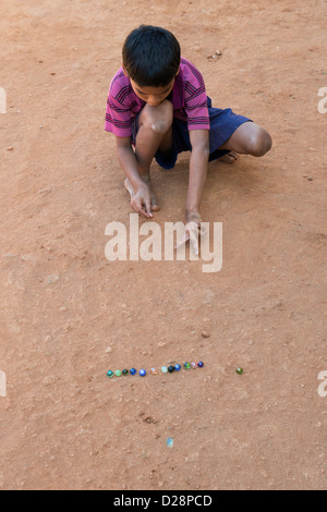 Indian boy playing marbles in a rural Indian village. Andhra Pradesh, India Stock Photo