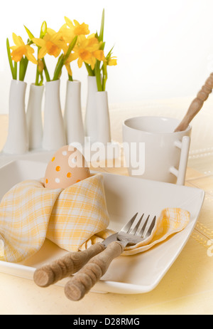 Folded napkin and daffodils on an Easter breakfast table Stock Photo