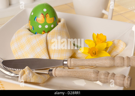 Decorated Easter table with napkin folded around an easter egg Stock Photo