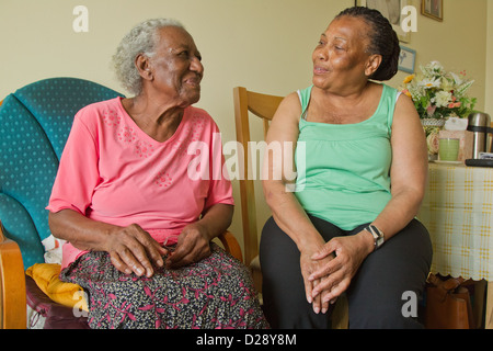 Carer and elderly visually impaired woman chatting Stock Photo