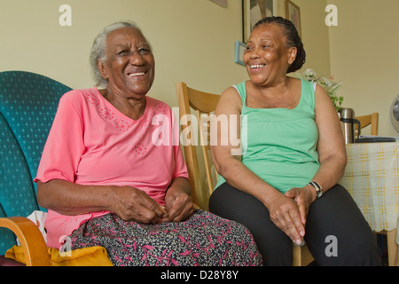 Carer and elderly visually impaired woman laughing Stock Photo