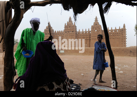 MALI Djenne , Tuareg man in front of Grand Mosque build from clay is UNESCO world heritage, man wearing Tagelmust turban and Boubou Stock Photo