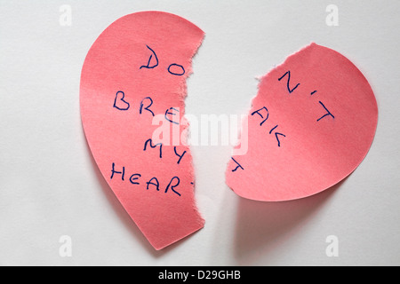 heartbroken - don't break my heart message written on torn up pink heart shaped sticky note isolated on white background Stock Photo