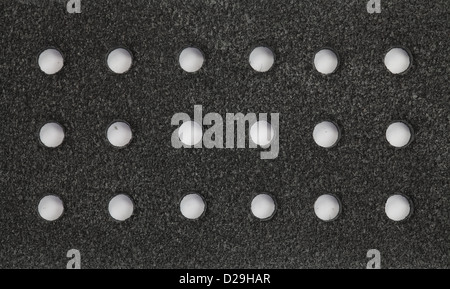 Close up photo of black leather. Leather is perforated by round holes. Stock Photo