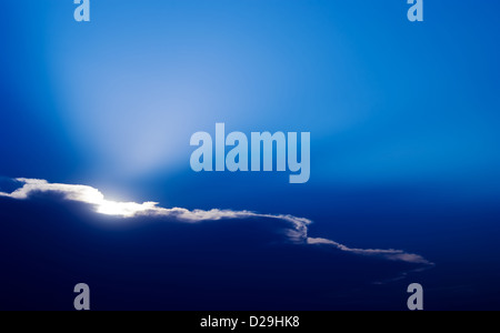 Sun behind clouds. The sun on a sunset disappearing behind the clouds Stock Photo