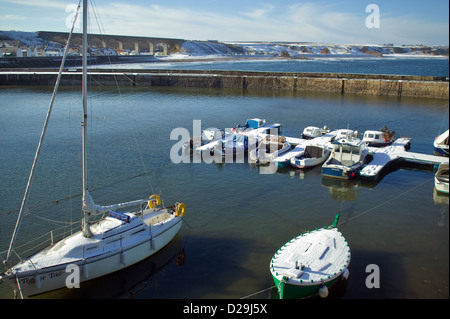 SMALL HARBOUR AT CULLEN  ON THE BANFFSHIRE COAST OF SCOTLAND IN WINTER WITH BOATS COVERED IN SNOW Stock Photo