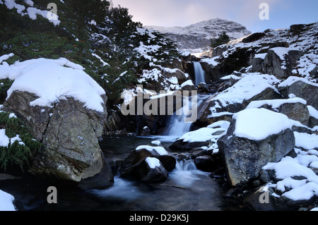 Waterfalls on Levers Water Beck in winter with the Old Man of Coniston in the background Stock Photo