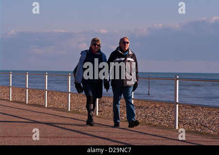 Front View Of A Middle Aged Man and Woman Walking Wearing Coats Stock Photo