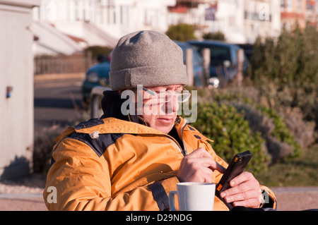 Elderly Man Texting Using A Mobile Phone Stock Photo