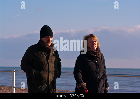 Front View Of A Middle Aged Man and Woman Walking Wearing Coats Stock Photo