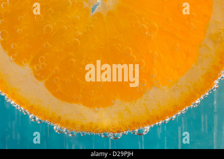 A slice of orange in a glass of sparkling mineral water Stock Photo