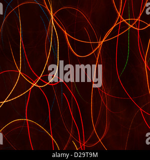 Red and orange light trails against a black background Stock Photo