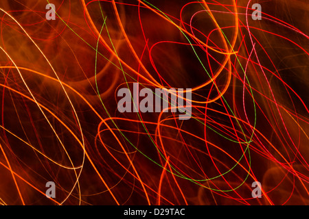 Red and orange light trails against a black background Stock Photo