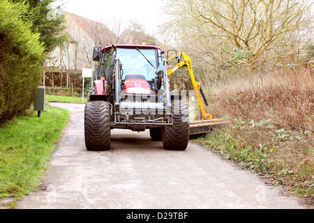 Large tractor mowing the grass verges in Bradley Stoke, Bristol, 17th January 2013 Stock Photo