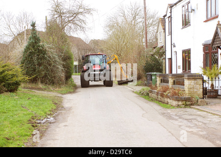 Large tractor mowing the grass verges in Bradley Stoke, Bristol, 17th January 2013 Stock Photo